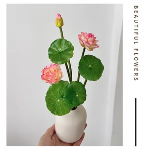 Detail of pink lotus artificial flower set in a white ceramic vase for home decoration