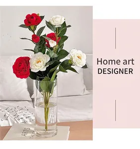 Camelie artificiali rosse e bianche in vaso di vetro su tavolo in legno decorativo