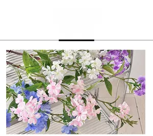 Close-up of multicolored silk jasmine bouquet with long green stems on a metal shelf