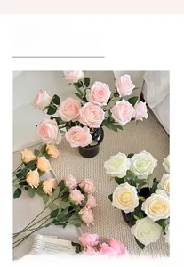 Detailed close-up of artificial silk roses in soft pink and cream for home table decor