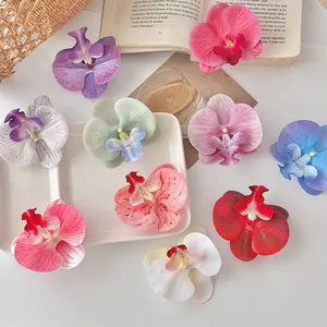 Flat lay van kleurrijke kunstmatige orchideeën op een wit bord voor DIY-decoraties