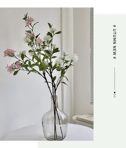 Detail of pink and white faux flowers in a clear glass vase for minimalist home decor