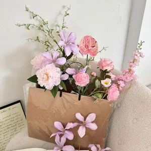 Detail of faux peonies and roses in a kraft paper bag on a cozy fleece armchair