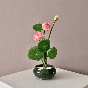 Zen style artificial pink lotus plant in a dark green ceramic pot for home desk decoration
