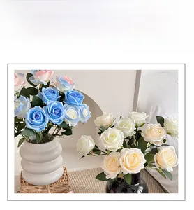 Detailed view of artificial silk roses in blue and cream colors inside stylish vases