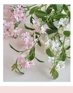 Close-up of artificial pink and white freesia flowers with detailed green leaf texture