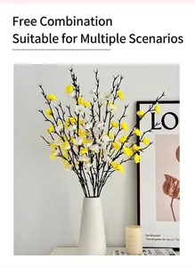 Detalle de flores de ciruelo artificiales blancas en un jarrón de cerámica minimalista