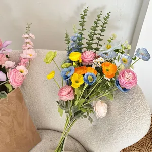 Detail of premium silk floral bouquet with colorful poppy and peony on a soft sofa
