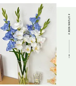 Dettaglio ravvicinato di gladioli artificiali blu e bianchi in un vaso di vetro