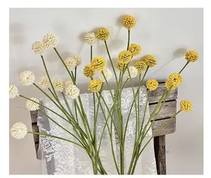 Detail van gele en witte kunstmatige trommelstokbloemen in een stijlvolle woonsetting