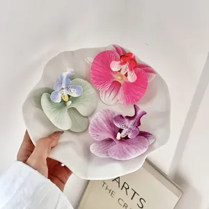 Drie kleurrijke kunstmatige orchideekoppen op keramische schaal voor DIY decor