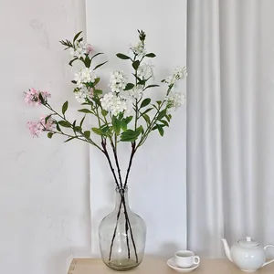 Elegant white faux freesia and hydrangea in a glass vase for minimalist home decor