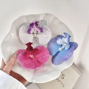 Close-up van drie kunstmatige orchideeënkoppen in wit, roze en blauw voor DIY-decoratie