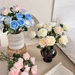 Artificial silk roses in white and blue hues displayed in a ceramic wavy vase