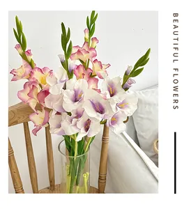 Dettaglio di gladioli artificiali realistici con petali rosa e viola in un vaso di vetro