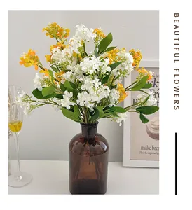Fleurs de jasmin artificielles blanches et jaunes dans un vase en verre marron