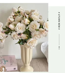 Détail de roses artificielles crème dans un vase en céramique blanche pour décoration