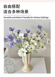 Dettaglio di fiori di cosmea artificiali viola e bianchi in un vaso di ceramica