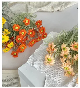 Close-up of realistic faux daisies with flocked grey-green leaves in warm vintage style