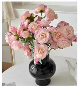 Roses artificielles roses dans un vase en céramique noire pour décoration de table