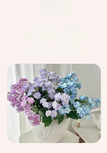 Detailed view of artificial purple and blue multi-layered jasmine flowers in a white vase