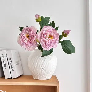 Kunstmatige pioenrozen boeket met zijden bloemen in een witte getextureerde keramiek vaas