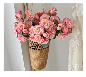 Roses artificielles roses dans un panier en paille tressé pour décoration murale