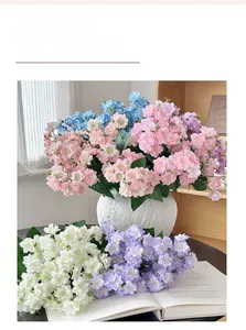 Detail of colorful artificial jasmine flower bouquet in textured white ceramic vase