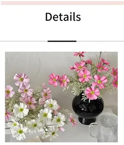 Dettaglio di fiori di cosmo artificiali rosa con un vaso sferico in ceramica nera lucida