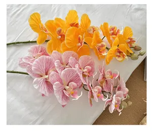 Detailed view of artificial Phalaenopsis orchids in vibrant orange and soft pink colors