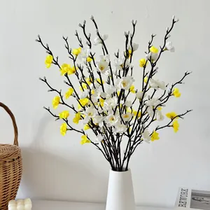Ramas de flores de ciruelo artificiales minimalistas blancas y amarillas en un jarrón