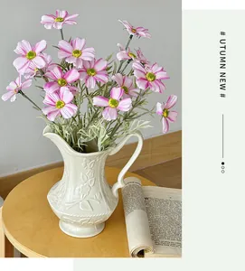 Detailrelief einer weißen Keramikvase mit rosa Kunstblumen für die Wohndekoration
