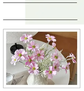 Dettaglio di fiori di cosmo artificiali rosa in un vaso di ceramica intagliata
