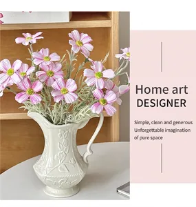 Dettaglio di margherite finte rosa in vaso di ceramica bianca con rilievo decor