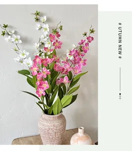 Dettaglio di fiori di gelsomino in seta bianca e magenta in un vaso di ceramica beige