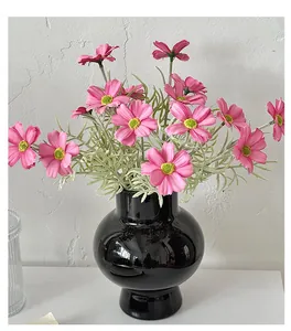 Rosa künstliche Kosmosblumen in glänzender schwarzer Vase für minimalistische Deko