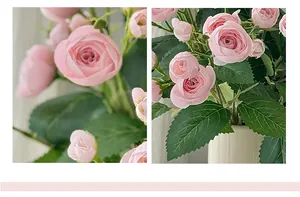Détail macro de boutons de camélia rose artificiels avec feuilles dans un vase blanc