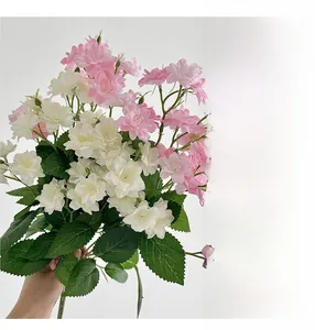Close-up of pink and white artificial jasmine bouquet with detailed green silk leaves
