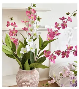 Dettaglio di fiori di gelsomino in seta rosa e bianchi in un vaso di ceramica vintage