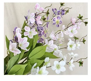 Dettaglio ravvicinato di rami di gelsomino artificiale con fiori bianchi e foglie