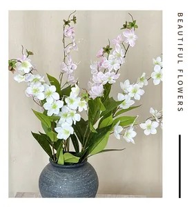 Dettaglio macro di fiori di gelsomino artificiale bianco in un vaso di ceramica grigia