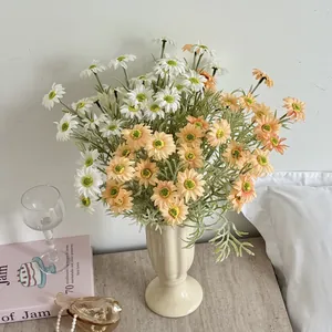 Artificial white and orange daisy bouquet in vintage ceramic vase for home decor