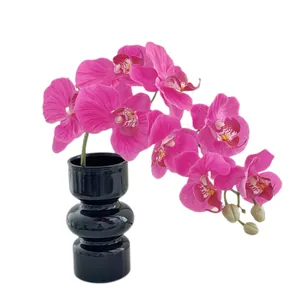 Deep pink artificial Phalaenopsis orchid in modern black tiered ceramic vase for home decor