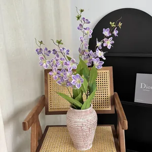 Fiori di gelsomino finti viola in vaso di ceramica materica su sedia vintage