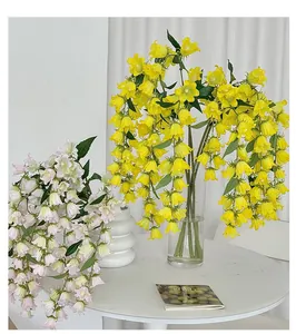 Detalle de lirios de los valles artificiales en amarillo y rosa en un jarrón