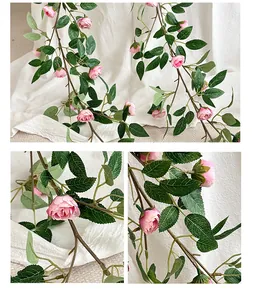 Primer plano de rosas de seda rosa artificiales con hojas verdes y vides marrones