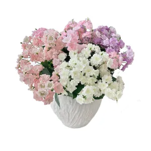 Artificial begonia and jasmine flower bouquet in a white textured modern vase