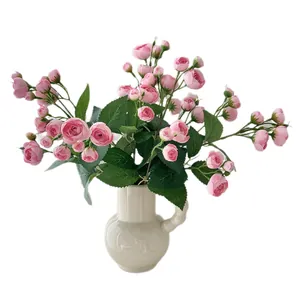 Bouquet de camélias roses artificiels dans un vase en céramique blanche pour la maison