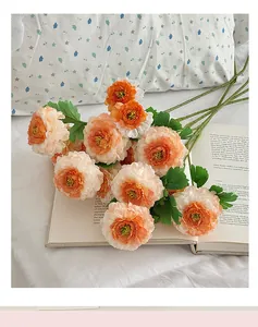 Macro detail of artificial orange ranunculus flowers with lush petals and green stems