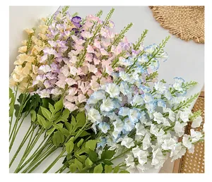 Close-up of realistic faux larkspur silk flowers in pastel cream, pink, and blue shades